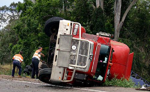 Clayton’s Towing employees work to recover a semi-trailer at Chatsworth yesterday morning after it rolled and spilled its load of scrap steel. Clayton’s Towing employees work to recover a semi-trailer at Chatsworth yesterday morning after it rolled and spilled its load of scrap steel.